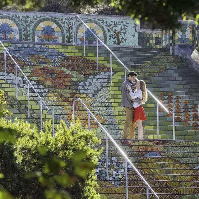 Foto scattata da un'angolazione di una coppia in piedi sui colorati gradini piastrellati di 朴槿惠林肯